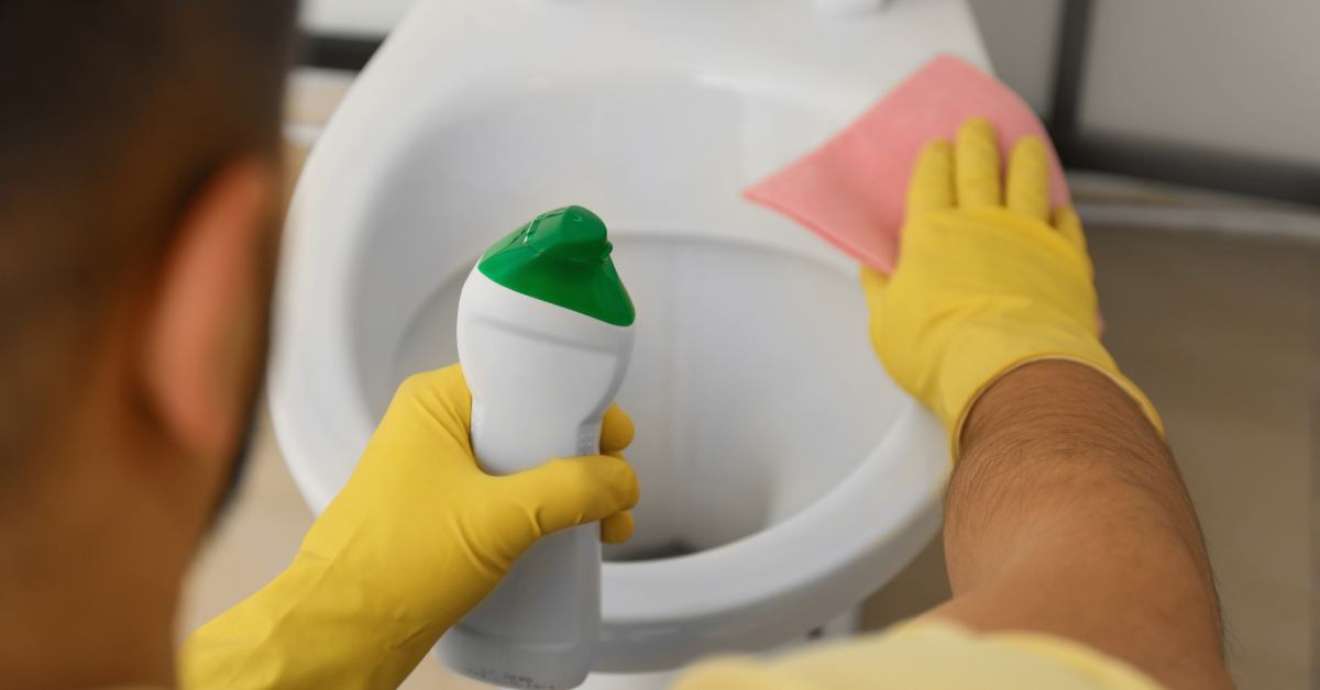 Ръка с ръкавица, която нанася препарат под ръба на чинията с крив накрайник.